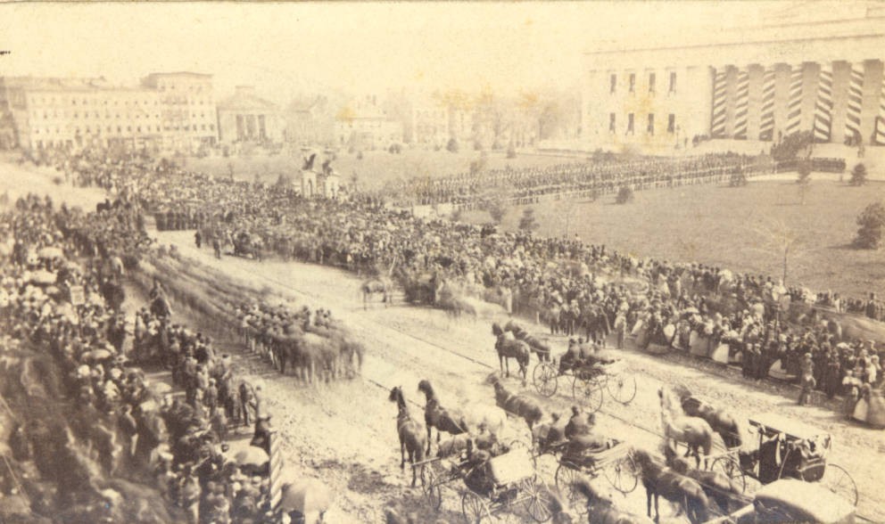 Thousands visit the Ohio Statehouse where Lincoln's body was laid. Funerary decorations can be seen on the capitol in the background. Via Ohio Memory.