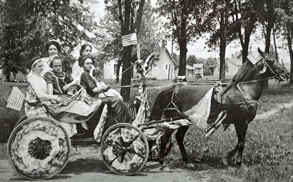 The Munn sisters of Portage, Ohio, in a decorated horse-drawn surrey for their local 4th of July parade. Courtesy of the Wood County District Public Library on Ohio Memory.