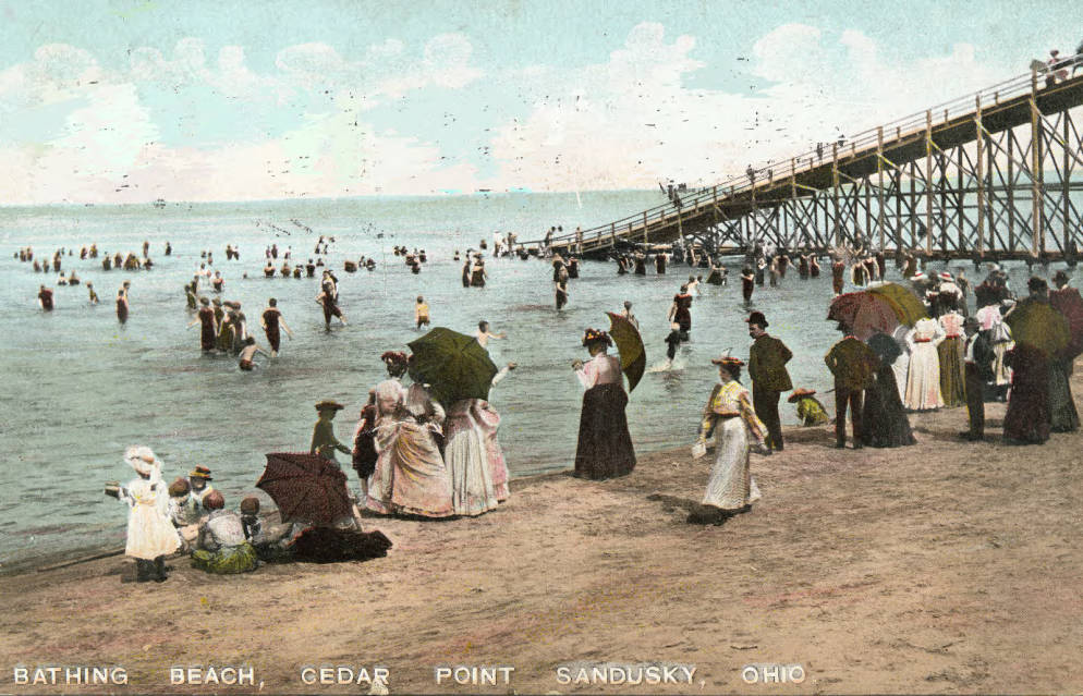 1910 postcard showing adults and children enjoying the beach at Cedar Point, via Ohio Memory.