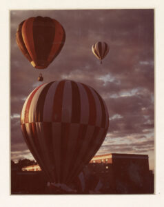 Three hot air balloons rise into a cloudy sky at Copeland Oaks Estates in Sebring, Ohio.